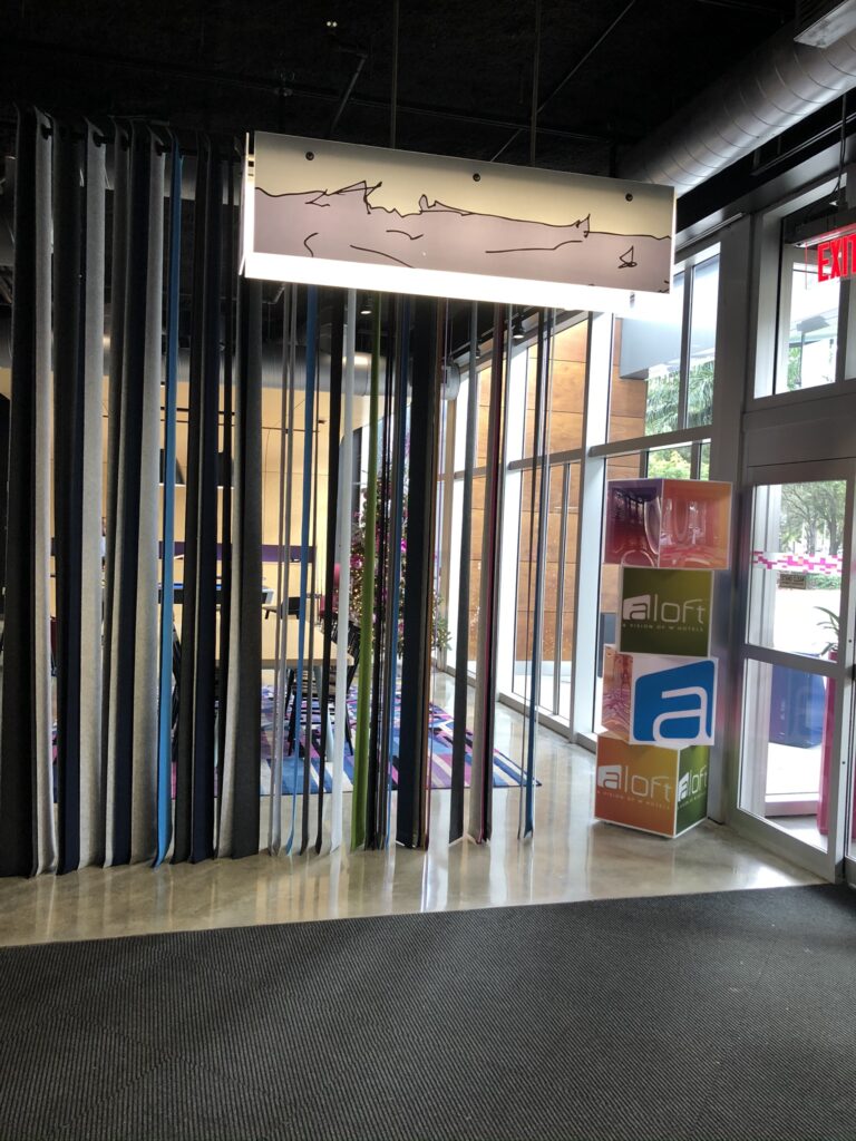 Aloft hotel entrance with branded elements and modern lobby access area renovated in Miami