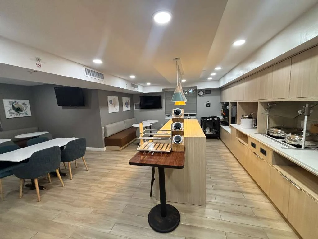 Renovated hotel breakfast and buffet at TownePlace Suites in Weston, Florida, with new millwork, lighting and food service line