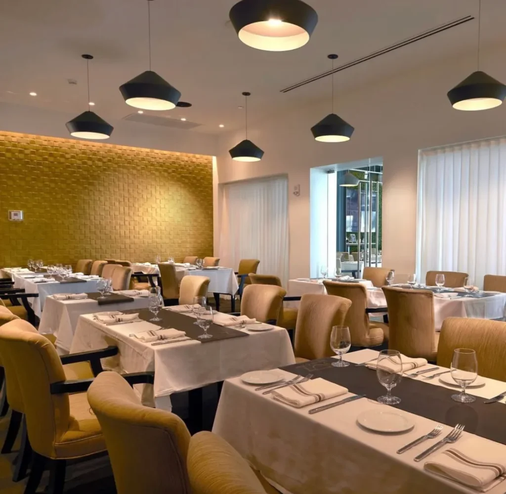 Restaurant interior dining area with modern lighting, tables and seating constructed during commercial project in Miami